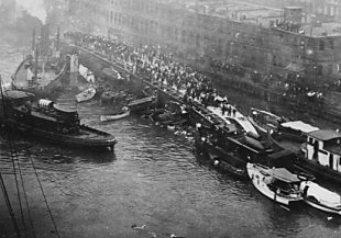 The Eastland on her side, with passengers standing on the hull